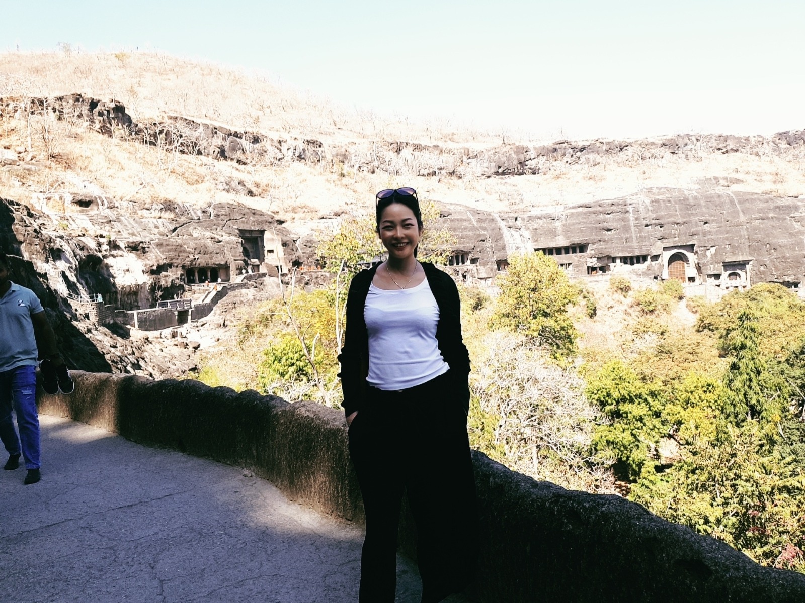 Camilla standing near ancient cave architecture